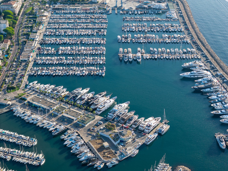 Aerial view of Port Vauban marina filled with numerous luxury yachts and sailboats docked in the clear blue waters of the Mediterranean Sea in Antibes Provence Alpes Cote d Azur France. Aerial view of Port Vauban marina filled with numerous luxury yachts and sailboats docked in the clear blue waters of the Mediterranean Sea in Antibes Provence Alpes Cote d Azur France.