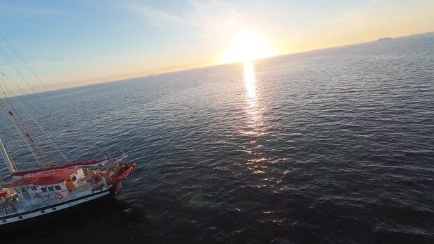 FPV aerial view of a sailing boat at sunset in Greenland. FPV aerial view of a sailing boat at sunset in Greenland.