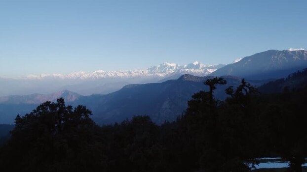 Aerial view of snowy Himalayan peaks and forests in India.
