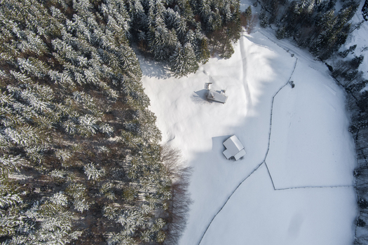 Brasov Brasov Romania 21 September 2026 Aerial view of snow covered forest and small wooden cabins in a winter landscape. Brasov Brasov Romania 21 September 2026 Aerial view of snow covered forest and small wooden cabins in a winter landscape.