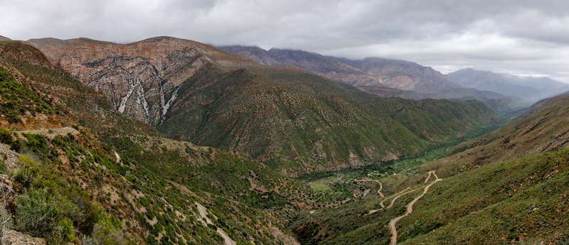 Aerial view of Die Hel Gamkaskloof valley with a winding road rugged mountain peaks and greenery in Central Karoo District Municipality Western Cape South Africa. Aerial view of Die Hel Gamkaskloof valley with a winding road rugged mountain peaks and greenery in Central Karoo District Municipality Western Cape South Africa.