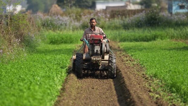 View of a farmer tilling soil with a power tiller in Nepalgunj Nepal. View of a farmer tilling soil with a power tiller in Nepalgunj Nepal.