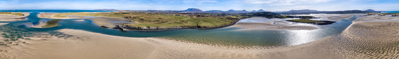 Aerial view of Ballyness Bay featuring expansive sandbanks tidal channels and lush green fields under a clear blue sky in Ballyness County Donegal Ireland. Aerial view of Ballyness Bay featuring expansive sandbanks tidal channels and lush green fields under a clear blue sky in Ballyness County Donegal Ireland.