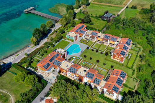 Aerial view of a residential complex with a swimming pool and solar panels on the shores of Lake Garda Italy. Aerial view of a residential complex with a swimming pool and solar panels on the shores of Lake Garda Italy.
