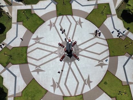 Aerial view of Alun Alun Pasuruan with a central monument geometric paving and green lawns with people walking in Kecamatan Panggungrejo Jawa Timur Indonesia. Aerial view of Alun Alun Pasuruan with a central monument geometric paving and green lawns with people walking in Kecamatan Panggungrejo Jawa Timur Indonesia.