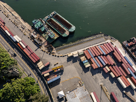 Aerial view of Rio Ozama with cargo barges shipping containers and port infrastructure in Santo Domingo Santo Domingo Dominican Republic.