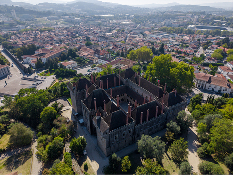 Aerial view of the historic Paco dos Duques de Braganca with its distinctive chimneys and central courtyard set within the urban landscape of Guimaraes Braga Portugal. Aerial view of the historic Paco dos Duques de Braganca with its distinctive chimneys and central courtyard set within the urban landscape of Guimaraes Braga Portugal.