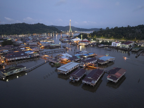 Aerial view of Kampong Ayer water village with houses on stilts and the illuminated RIPAS Bridge at twilight in Bandar Seri Begawan Brunei Muara District Brunei. Aerial view of Kampong Ayer water village with houses on stilts and the illuminated RIPAS Bridge at twilight in Bandar Seri Begawan Brunei Muara District Brunei.