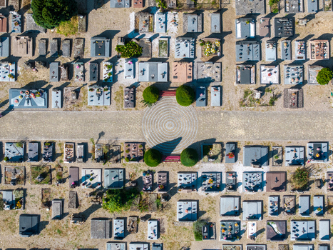 Aerial view of the historic cemetery in Neuf Brisach with rows of gravestones and a central circular stone pattern surrounded by manicured bushes in Neuf Brisach Grand Est France.