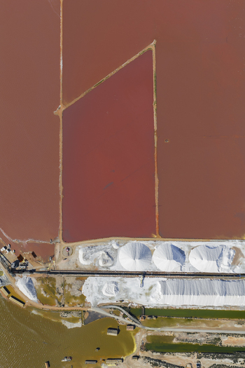 Aerial view of vibrant pink salt ponds contrasting starkly with the bright white salt mounds along the coast San Pedro del Pinatar Region of Murcia Spain. Aerial view of vibrant pink salt ponds contrasting starkly with the bright white salt mounds along the coast San Pedro del Pinatar Region of Murcia Spain.