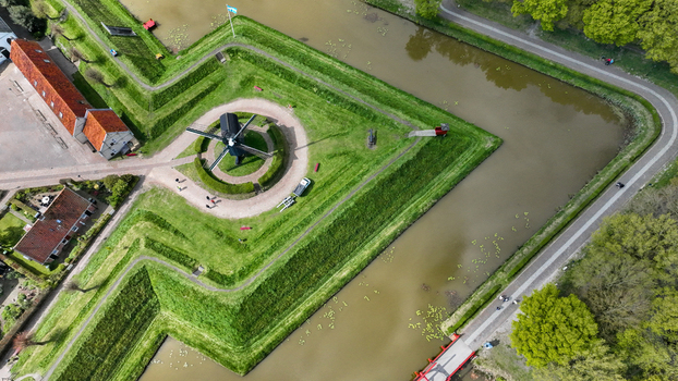 Aerial view of the star shaped Fort Bourtange with green ramparts water moats and a historic windmill in Bourtange Groningen Netherlands. Aerial view of the star shaped Fort Bourtange with green ramparts water moats and a historic windmill in Bourtange Groningen Netherlands.