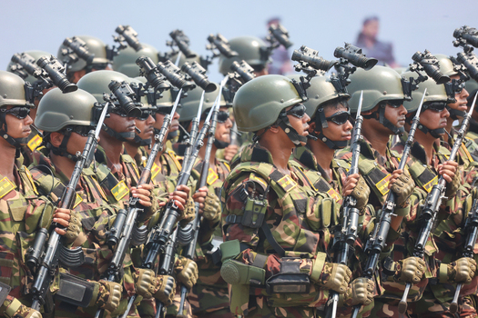 Dhaka Bangladesh 25 March 2026 View of uniformed soldiers in camouflage helmets and rifles standing in formation under a bright sky.