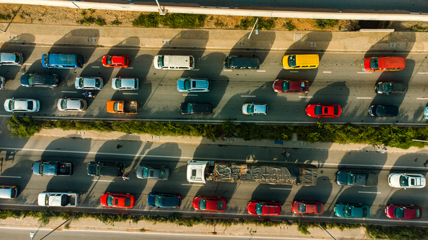 Aerial view of Pokuase Interchange with heavy traffic flow on a multi lane highway featuring cars and a truck casting long shadows in Ga North Municipal Greater Accra Region Ghana. Aerial view of Pokuase Interchange with heavy traffic flow on a multi lane highway featuring cars and a truck casting long shadows in Ga North Municipal Greater Accra Region Ghana.