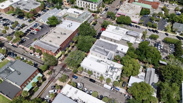 Aerial view of buildings with a mix of brick and white facades interspersed with lush trees and parked cars Fernandina Beach Florida United States. Aerial view of buildings with a mix of brick and white facades interspersed with lush trees and parked cars Fernandina Beach Florida United States.