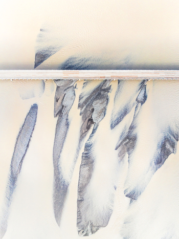 Aerial view of a braided river with intricate sediment patterns and a bridge crossing the glacial water in Iceland. Aerial view of a braided river with intricate sediment patterns and a bridge crossing the glacial water in Iceland.