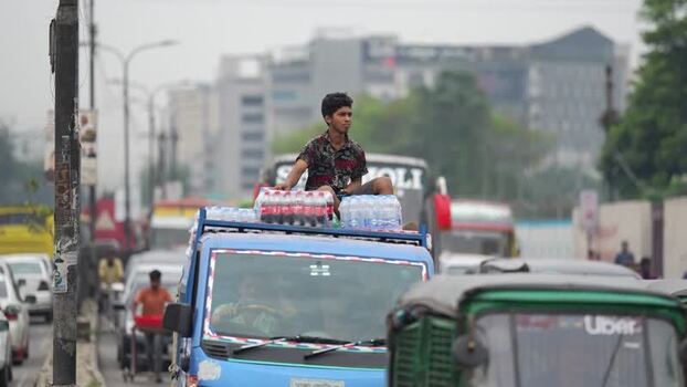 View of a man sitting on a truck in traffic in Dhaka Bangladesh.