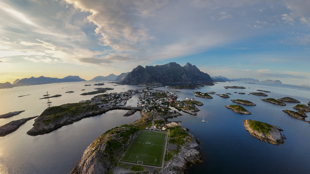 Aerial view of the soccer field in Henningsvaer surrounded by rocky islands and mountains in the Lofoten archipelago in Vagan Municipality Nordland Norway. Aerial view of the soccer field in Henningsvaer surrounded by rocky islands and mountains in the Lofoten archipelago in Vagan Municipality Nordland Norway.