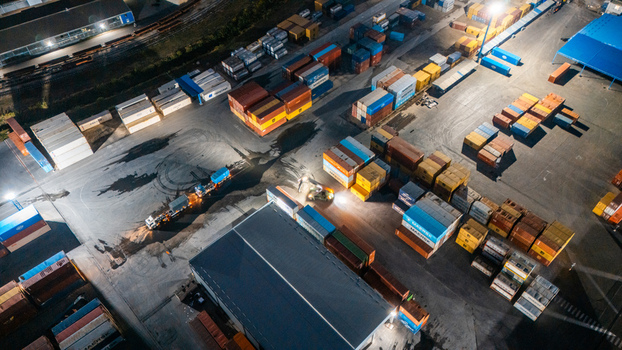 Aerial view of RTC Luka Leget container terminal at night with stacks of colorful shipping containers a truck and bright floodlights in Sremska Mitrovica Vojvodina Serbia. Aerial view of RTC Luka Leget container terminal at night with stacks of colorful shipping containers a truck and bright floodlights in Sremska Mitrovica Vojvodina Serbia.