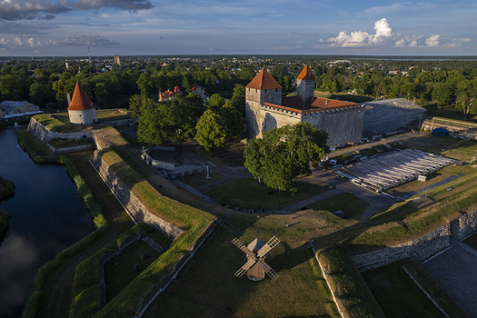 Aerial view of Kuressaare Castle a medieval stone fortress with red tiled roofs surrounded by defensive walls a moat and a wooden windmill in Kuressaare Saare County Estonia.