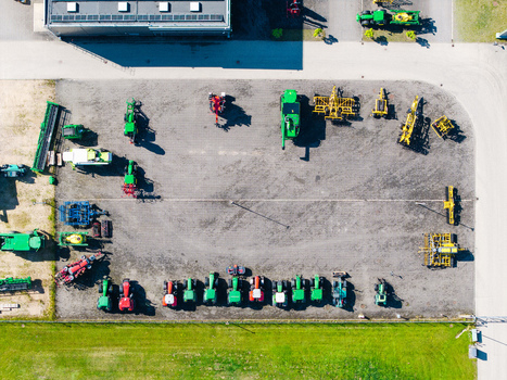 Aerial view of a farm equipment supplier yard featuring various tractors and agricultural machinery parked on a gravel lot in Kekava Kekava Municipality Latvia. Aerial view of a farm equipment supplier yard featuring various tractors and agricultural machinery parked on a gravel lot in Kekava Kekava Municipality Latvia.