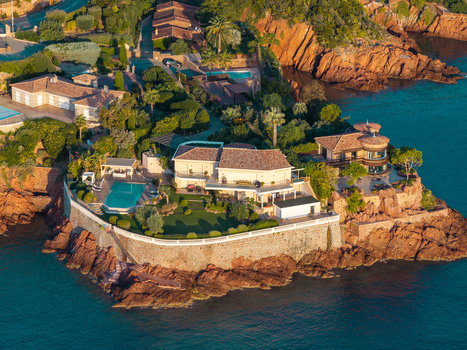 Aerial view of luxury villas with swimming pools and lush gardens situated on the red rock cliffs of Le Trayas in Saint Raphael Provence Alpes Cote d Azur France. Aerial view of luxury villas with swimming pools and lush gardens situated on the red rock cliffs of Le Trayas in Saint Raphael Provence Alpes Cote d Azur France.