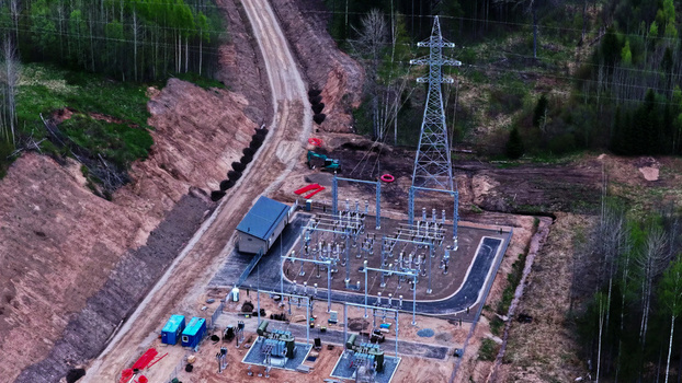 Aerial view of an electrical substation situated in a forested area with power lines transformers and a dirt road in Latvia. Aerial view of an electrical substation situated in a forested area with power lines transformers and a dirt road in Latvia.