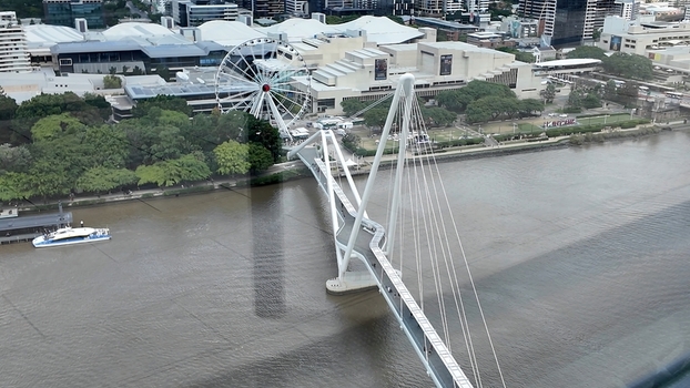 View of the Kurilpa Bridge spanning the Brisbane River with the Wheel of Brisbane in the background surrounded by urban parkland and city buildings in Brisbane Queensland Australia. View of the Kurilpa Bridge spanning the Brisbane River with the Wheel of Brisbane in the background surrounded by urban parkland and city buildings in Brisbane Queensland Australia.