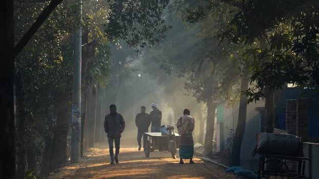 View of people walking on a misty road in Bogura Bangladesh.