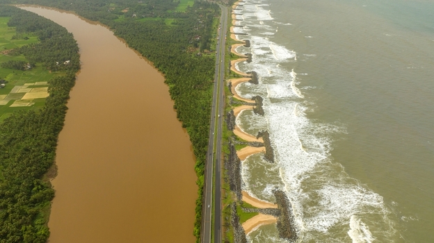 Aerial view of Maravanthe beach with the Arabian Sea on one side and the Suparnika River on the other separated by a highway in Maravanthe Karnataka India. Aerial view of Maravanthe beach with the Arabian Sea on one side and the Suparnika River on the other separated by a highway in Maravanthe Karnataka India.