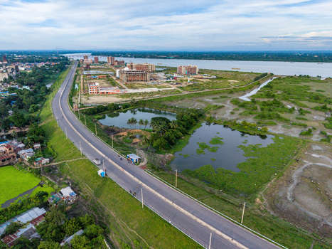 Aerial view of Kalurghat New River view Road winding alongside the Karnaphuli River with surrounding wetlands green fields and urban development in Chattogram Chittagong Division Bangladesh.