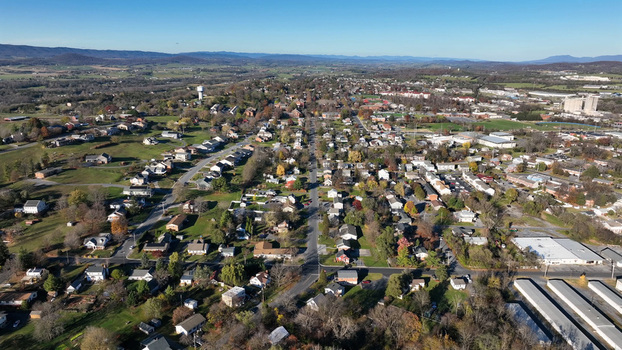 Aerial view of the city of Harrisonburg with residential neighborhoods local roads and autumn foliage under a clear blue sky in Harrisonburg Virginia United States. Aerial view of the city of Harrisonburg with residential neighborhoods local roads and autumn foliage under a clear blue sky in Harrisonburg Virginia United States.