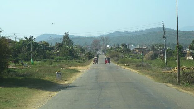 View of a road with auto rickshaws and hills in Surkhet Nepal.
