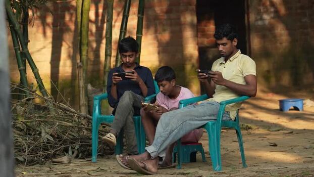 View of young men using smartphones in Bogura Bangladesh. View of young men using smartphones in Bogura Bangladesh.