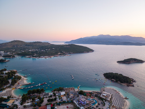 Aerial view of turquoise sea small islands and sandy beaches with umbrellas at sunset in Ksamil Vlore County Albania. Aerial view of turquoise sea small islands and sandy beaches with umbrellas at sunset in Ksamil Vlore County Albania.