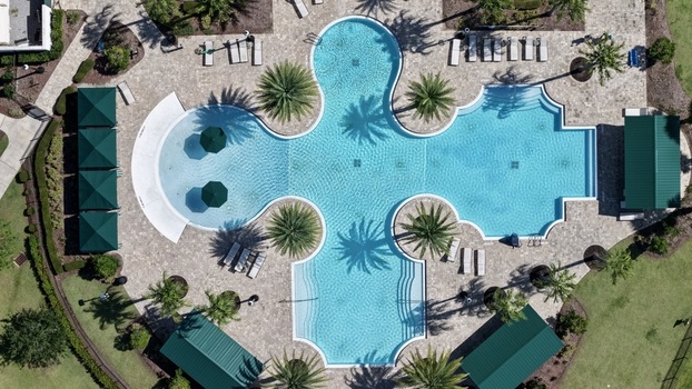 Aerial view of the swimming pool at Windward Ranch with palm trees lounge chairs and green cabanas in St. Johns County Florida United States. Aerial view of the swimming pool at Windward Ranch with palm trees lounge chairs and green cabanas in St. Johns County Florida United States.