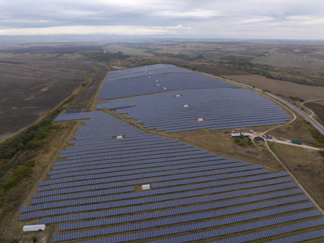 Aerial view of a large solar farm with rows of photovoltaic panels installed on rolling hills in the countryside of Bulgaria. Aerial view of a large solar farm with rows of photovoltaic panels installed on rolling hills in the countryside of Bulgaria.