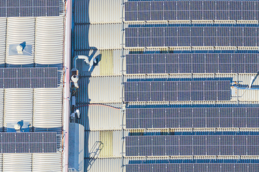 Aerial view of solar panels installed on a large industrial roof with metal corrugated sheets and ventilation systems in Arezzo Tuscany Italy. Aerial view of solar panels installed on a large industrial roof with metal corrugated sheets and ventilation systems in Arezzo Tuscany Italy.