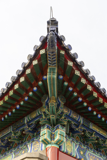 View of the intricate colorful eaves and traditional tiled roof of a historic Chinese palace building Beijing Beijing China. View of the intricate colorful eaves and traditional tiled roof of a historic Chinese palace building Beijing Beijing China.