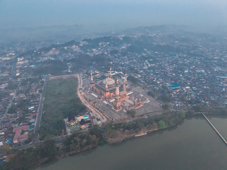 Aerial view of the Baitul Muttaqien Mosque at the East Kalimantan Islamic Center with its prominent domes and minarets near the river in Samarinda East Kalimantan Indonesia.