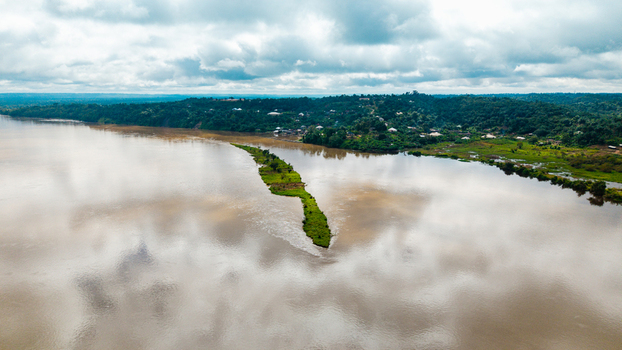 Aerial view of the Cross River with a small green island and lush riverbanks under a cloudy sky in Itu Akwa Ibom Nigeria. Aerial view of the Cross River with a small green island and lush riverbanks under a cloudy sky in Itu Akwa Ibom Nigeria.