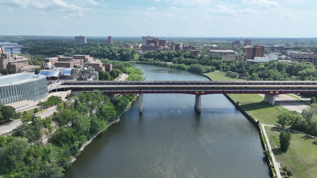 Aerial view of the Washington Avenue Bridge stretching across the Mississippi River framed by lush greenery and buildings Minneapolis Minnesota United States.