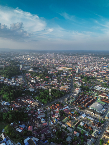 Aerial view of the city of Samarinda with its dense urban landscape residential rooftops lush green trees and winding roads in Samarinda Kalimantan Timur Indonesia. Aerial view of the city of Samarinda with its dense urban landscape residential rooftops lush green trees and winding roads in Samarinda Kalimantan Timur Indonesia.