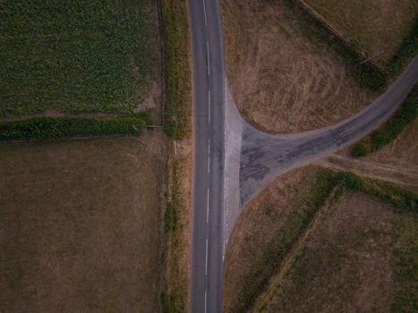 Aerial view of a rural road junction surrounded by green fields and hedgerows in Looe Cornwall United Kingdom. Aerial view of a rural road junction surrounded by green fields and hedgerows in Looe Cornwall United Kingdom.