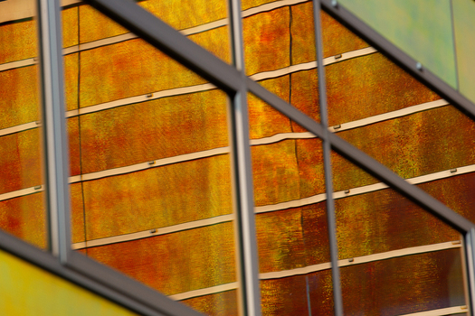 View of the building s facade reflecting a warm golden light creating a mesmerizing blend of colors and textures in Almere Flevoland Netherlands. View of the building s facade reflecting a warm golden light creating a mesmerizing blend of colors and textures in Almere Flevoland Netherlands.