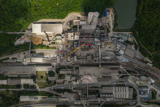 Aerial view of an industrial cement factory complex featuring large silos and warehouses nestled within a dense green forest Mokra Horakov Jihomoravsky kraj Czechia. Aerial view of an industrial cement factory complex featuring large silos and warehouses nestled within a dense green forest Mokra Horakov Jihomoravsky kraj Czechia.
