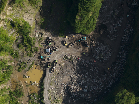 Aerial view of Tambang Pasir Merapi Kali Gendol Sand Mine with excavators and trucks on dirt paths near a pond in Kecamatan Cangkringan Daerah Istimewa Yogyakarta Indonesia. Aerial view of Tambang Pasir Merapi Kali Gendol Sand Mine with excavators and trucks on dirt paths near a pond in Kecamatan Cangkringan Daerah Istimewa Yogyakarta Indonesia.