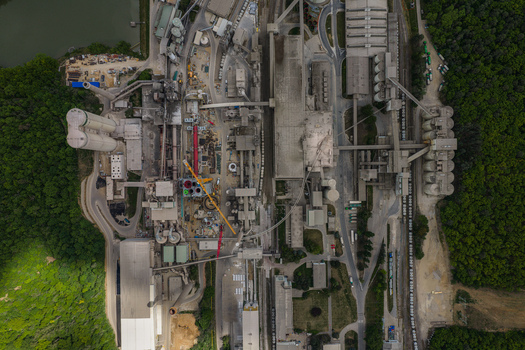Aerial view of a large industrial cement plant with silos and conveyor belts surrounded by dense green forest Mokra Horakov Jihomoravsky kraj Czechia. Aerial view of a large industrial cement plant with silos and conveyor belts surrounded by dense green forest Mokra Horakov Jihomoravsky kraj Czechia.