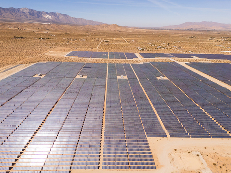 Aerial view of a vast solar farm with rows of photovoltaic panels set against a desert landscape and rugged mountains under a clear sky Lucerne Valley California United States. Aerial view of a vast solar farm with rows of photovoltaic panels set against a desert landscape and rugged mountains under a clear sky Lucerne Valley California United States.
