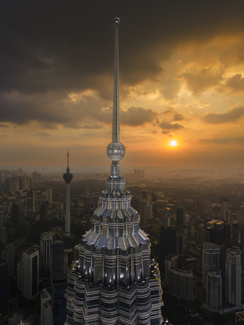 Kuala Lumpur Malaysia 11 March 2026 Aerial view of the Petronas Twin Towers spire and the KL Tower against a dramatic sunset sky over the city skyline.