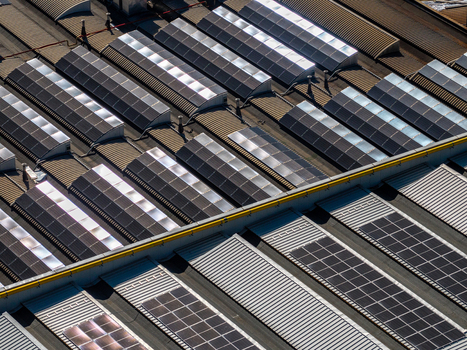 Aerial view of industrial building roof with rows of solar panels and skylights in Spoleto Umbria Italy. Aerial view of industrial building roof with rows of solar panels and skylights in Spoleto Umbria Italy.